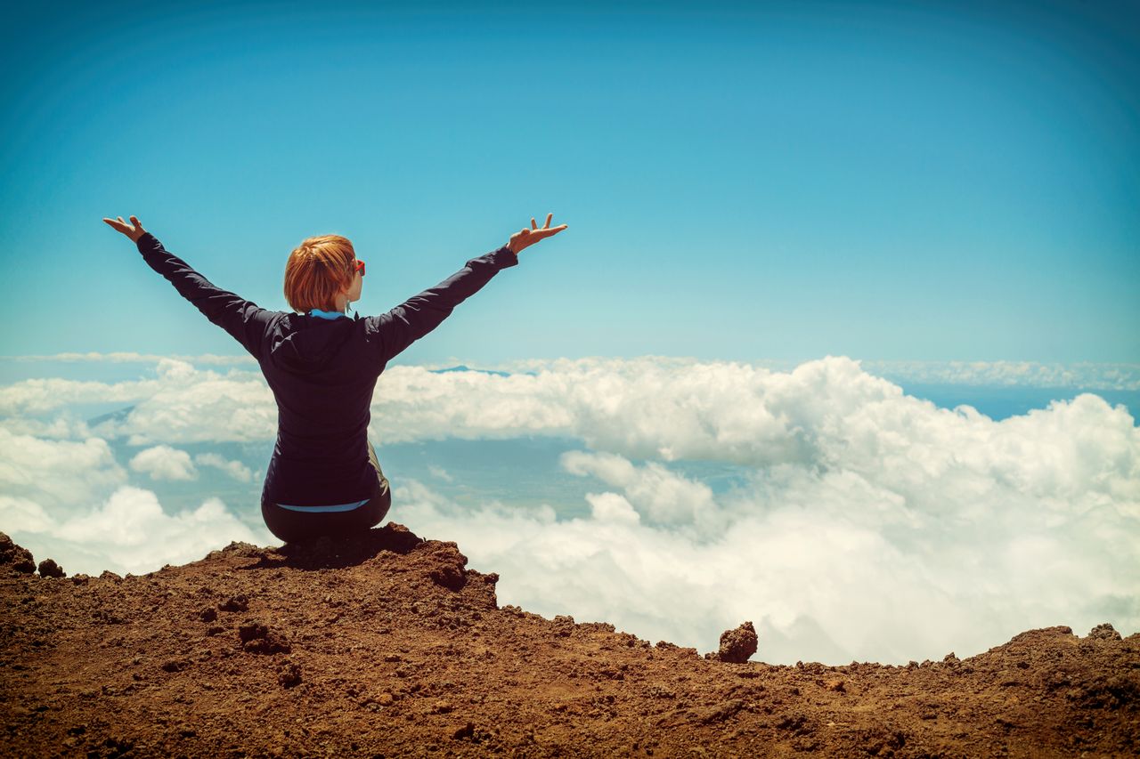 Mastering the First Impression: Your intriguing post title goes here A woman enjoys a scenic view atop a cliff in Kula, Hawaii, surrounded by clouds and blue sky.