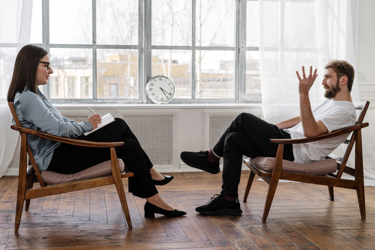 Crafting Captivating Headlines: Your awesome post title goes here A therapist engaging in a counseling session with a male patient to support mental health.